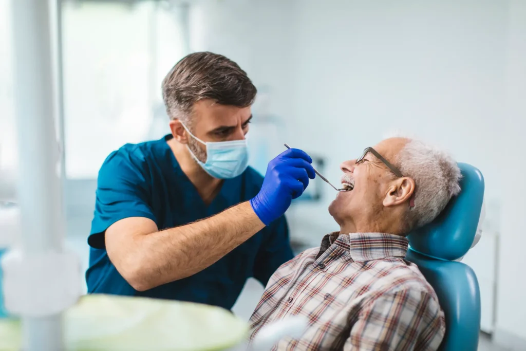 A dental professional examining an elderly patient's teeth during a routine check-up in Monett, MO