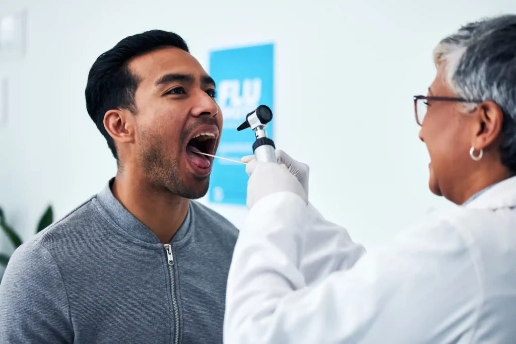 Doctor performing oral cancer screening on patient during checkup in Monett, MO