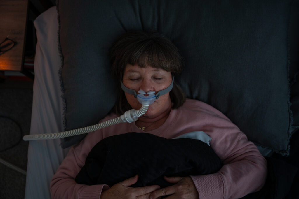 Top Down Shot of A Senior Adult Woman Wearing a CPAP (Continuous positive airway pressure) Machine after being diagnosed with Sleep Apnea