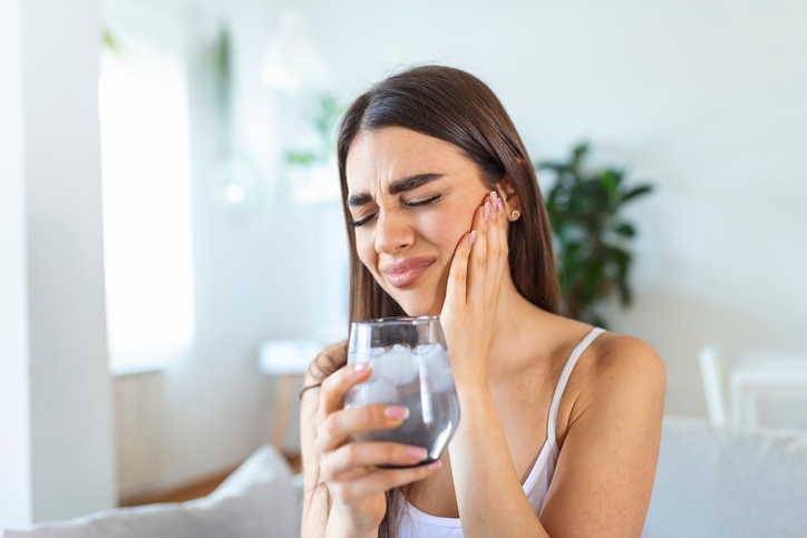 Person holding jaw with tooth pain and cold sensitivity in Monett, MO