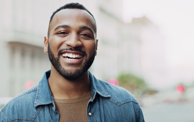 Bright smiling patient showing healthy teeth outdoors in Monett, MO