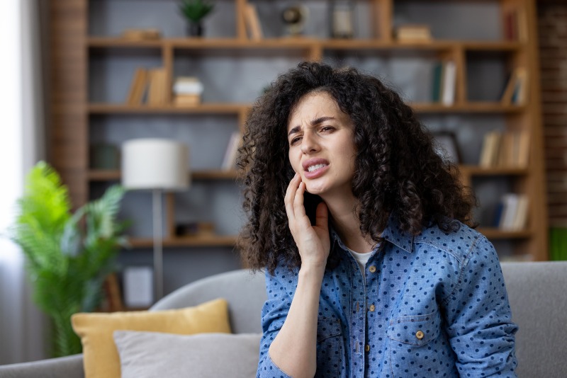Person experiencing tooth pain and seeking emergency dental care in Monett, MO